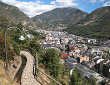 [1] befestigter Fußweg mit Straßenleuchte, parallel laufendem Gewässer und Handlauf in Andorra