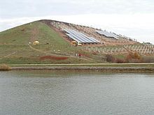 [1] abgedeckter Müllberg mit nachgerüsteten Solaranlagen, zur weiteren Nutzung der Erhebung