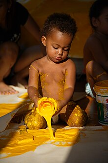 [2] Ein Kind leert Farbe aus