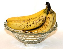 [1,3] Bananen mit ihrer gelben Schale in einer Obstschale.