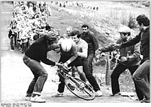 [1] Zuschauer helfen einem Radfahrer nach einem Sturz.