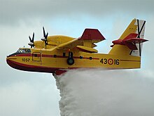 [1] Löschflugzeug beim Abwerfen (fachsprachlich „Auslösen“) des Löschwassers