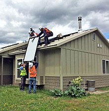 [1] Solarmodule werden auf einem Hausdach montiert.