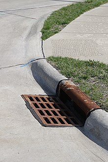 [1] Der Bordstein verläuft um die Kurve und ist vor dem Kanalgitter passend gefärbt.