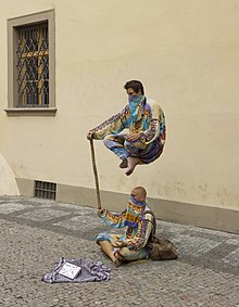 [1] Es sind gleich zwei Illusionen, dass ein Mann über dem anderen schweben könnte oder der untere den oberen an einem Stock halten könnte.