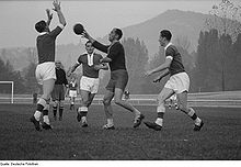 [1] Männer spielen Feldhandball.