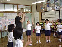 [1] ein Grundschullehrer mit seinen Schülern