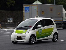 [1] Ein Elektroauto fährt auf der Straße.