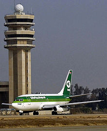 [1] Tower auf dem Baghdad International Airport, davor ein Flugzeug