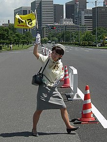 [1] Eine Frau hält eine Fahne hoch.