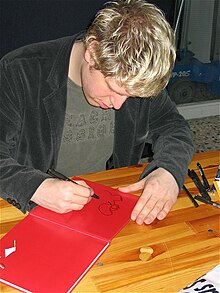 [1] Der Autor Joscha Sauer gibt ein Autogramm.