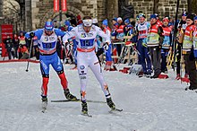 [1] Zwei Sportler kämpfen in einem Skilanglauf gegeneinander.