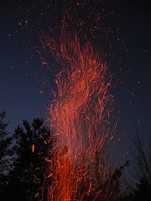 [1] Zahlreiche Funken eines Holzfeuers