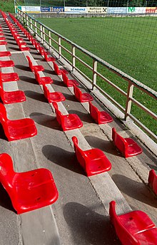 [1] rote Sitzplätze auf einem Sportplatz